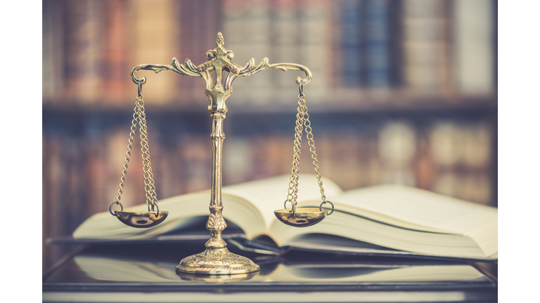 Legal office of lawyers, justice and law concept : Judge gavel or a hammer and a base used by a judge person on a desk in a courtroom with blurred weight scale of justice, bookshelf background behind.