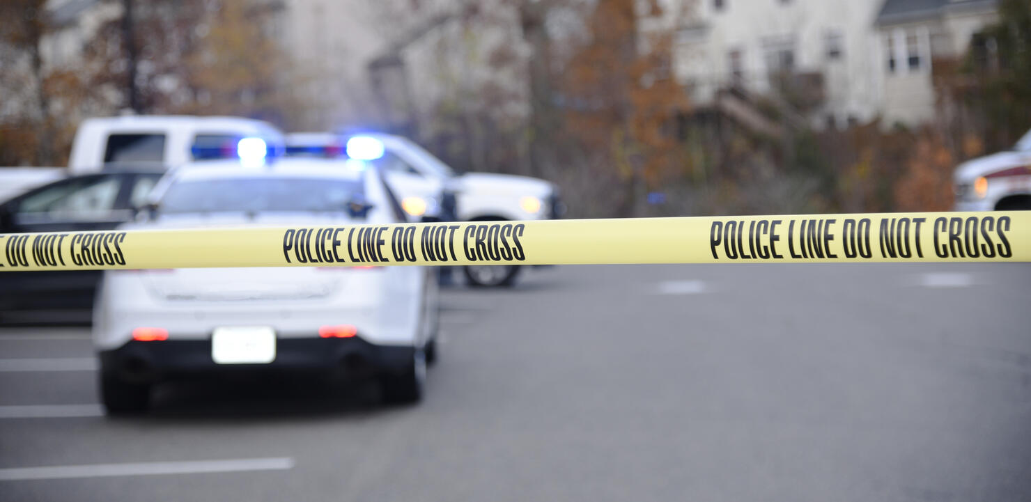 Police tape blocking access to a crime scene.