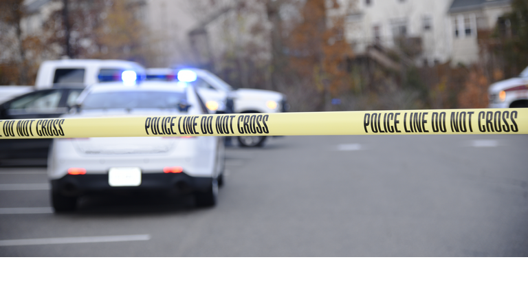 Police tape blocking access to a crime scene.