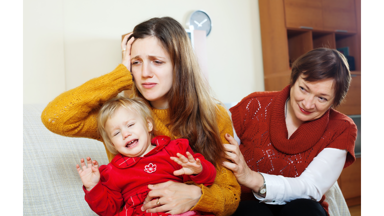 Mature woman comforting distressed woman with baby