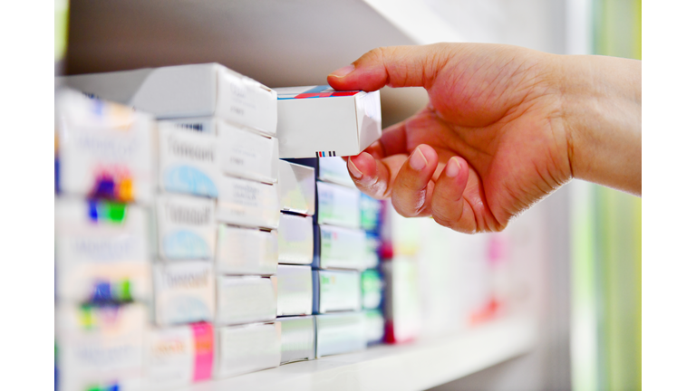 Hand holding medicine box in pharmacy drugstore.