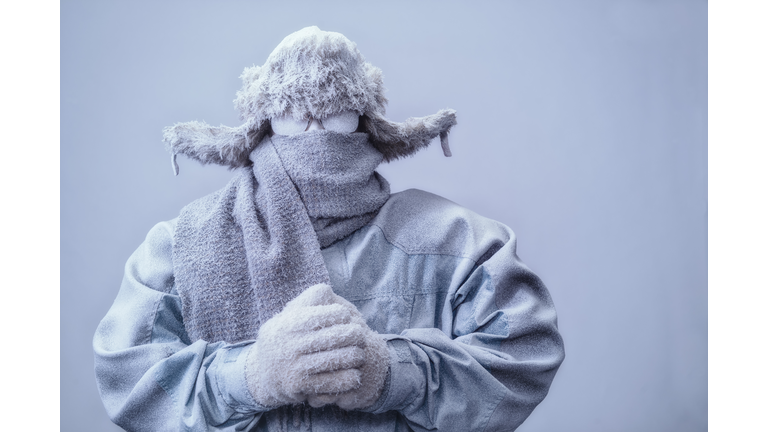 Man in parka, hat and scarf frozen from the cold