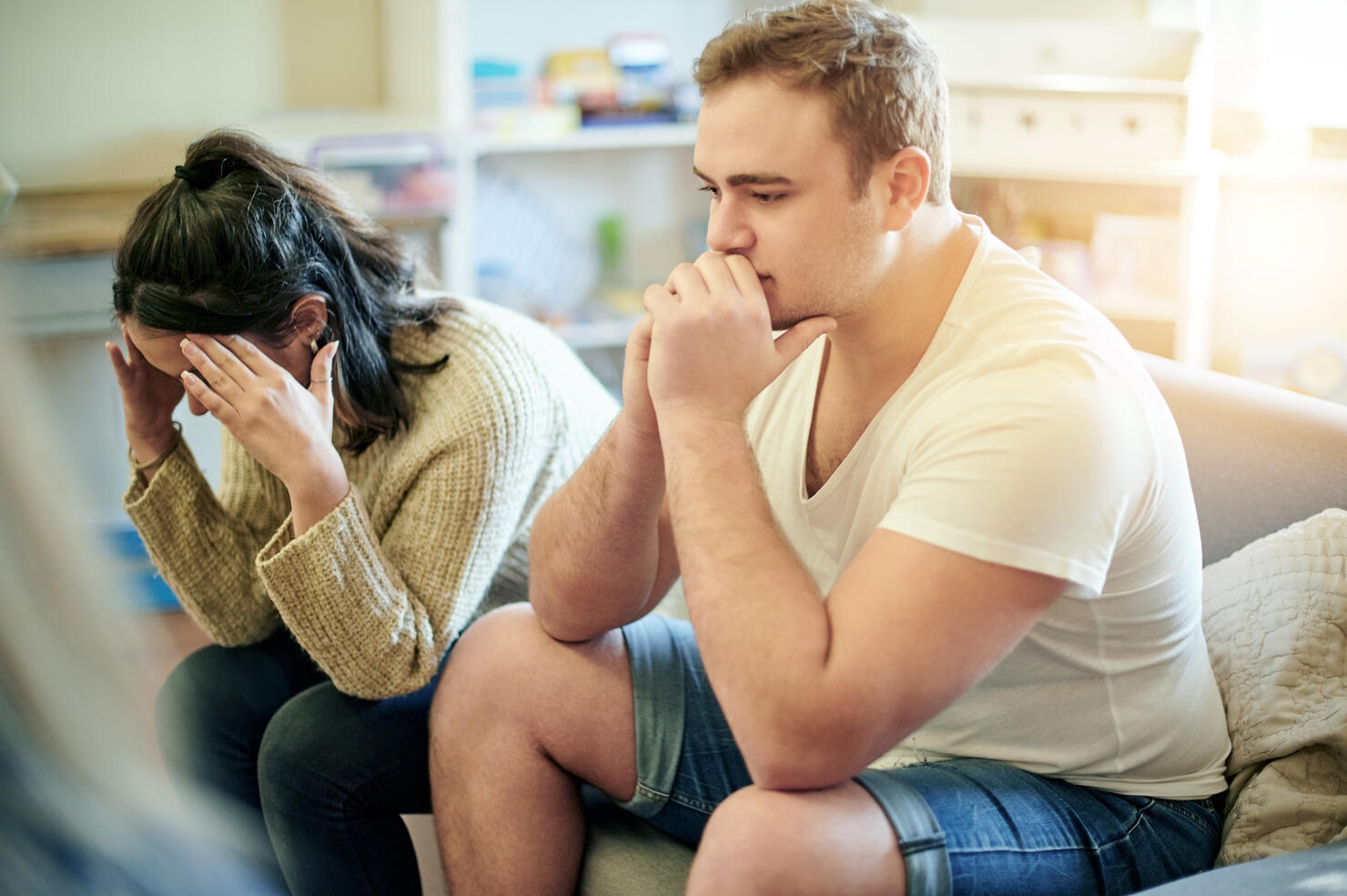 Conflict, upset and couple fighting on a sofa for toxic, cheating or relationship breakup. Upset, problem and frustrated young man and woman in an argument together in the living room of their home.