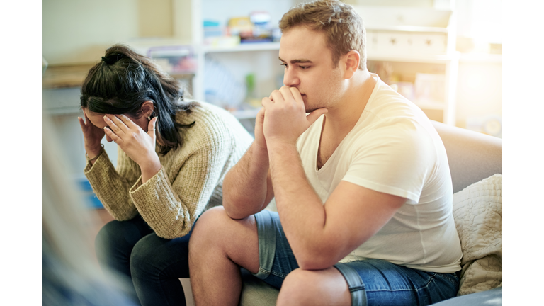 Conflict, upset and couple fighting on a sofa for toxic, cheating or relationship breakup. Upset, problem and frustrated young man and woman in an argument together in the living room of their home.