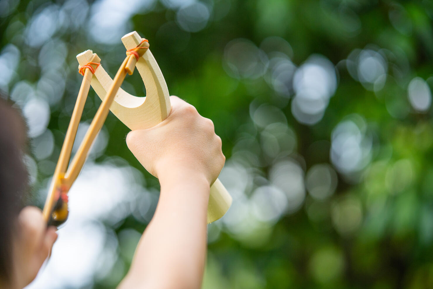 A boy shoots a slingshot .