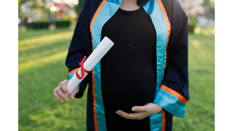 Young pregnant woman got master's degree diploma