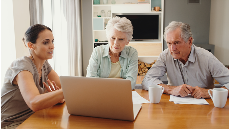 Financial advisor, retired couple and a laptop, consulting over a contract. Elderly man and woman meeting a consultant, talking budget for insurance, banking or planning an investment in retirement.