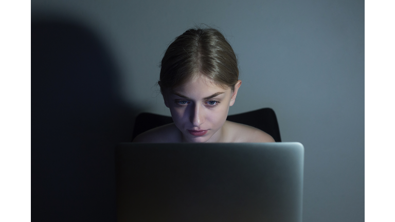 Woman working on laptop at night
