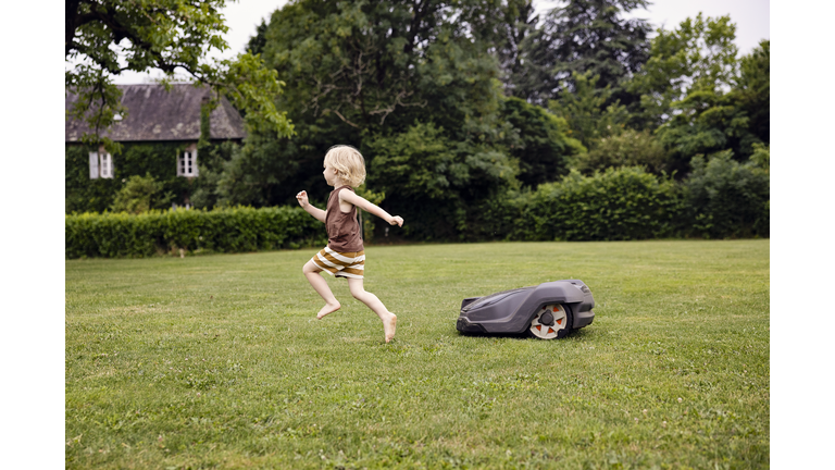 Robot lawn mower in summer garden