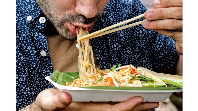 Tourists eating Pad Thai. Traditional street food in Thailand