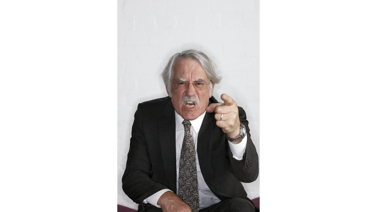 Angry senior businessman pointing to camera