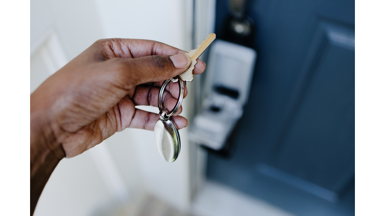 Real Estate Agent Accesses House Key From Lockbox Hanging on House's Front Door Handle