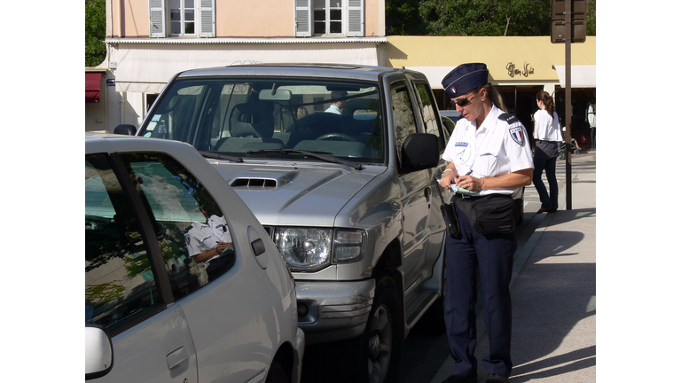 Female police officer fining a car