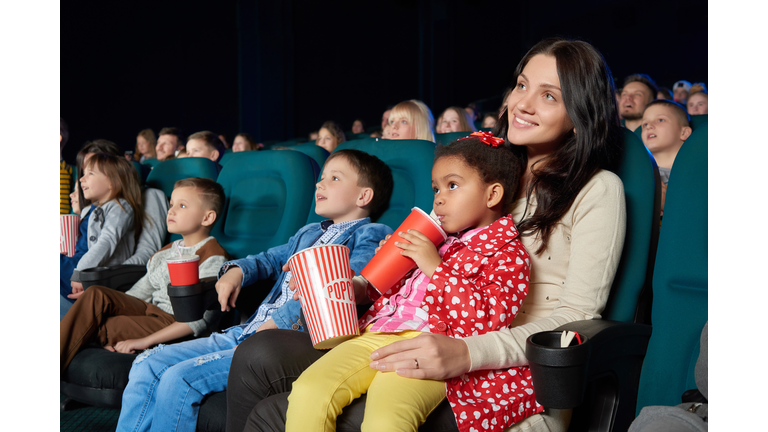 Children with parents enjoying a movie together at the cinema