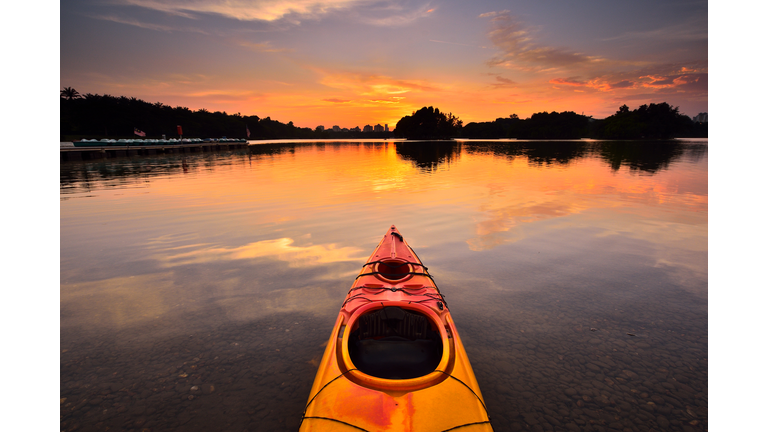 Canoe on water during sunset