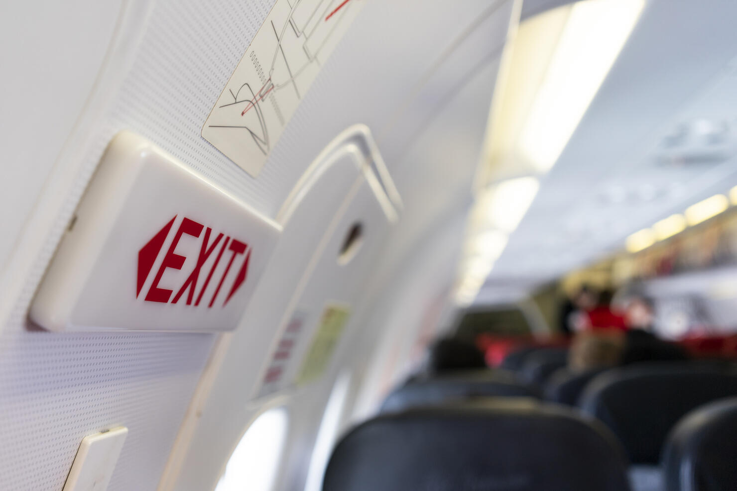 close up shot sign in airplane near emergency exit doors