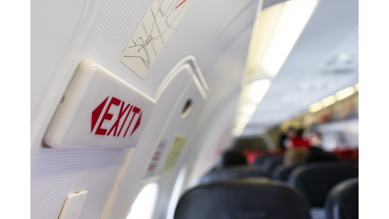 close up shot sign in airplane near emergency exit doors