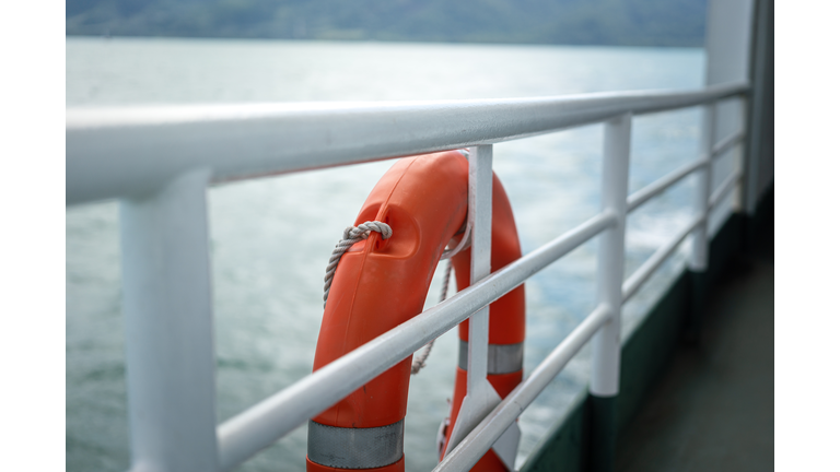 A rescue lifebuoy on ship corridor rail - Emergency equipment.