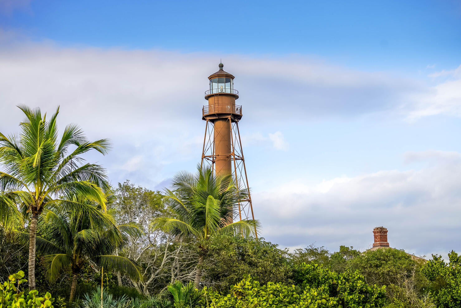 Scenic view of lighthouse on Sanibel Island with blue sky and puffy white clouds