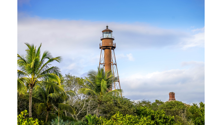 Scenic view of lighthouse on Sanibel Island with blue sky and puffy white clouds