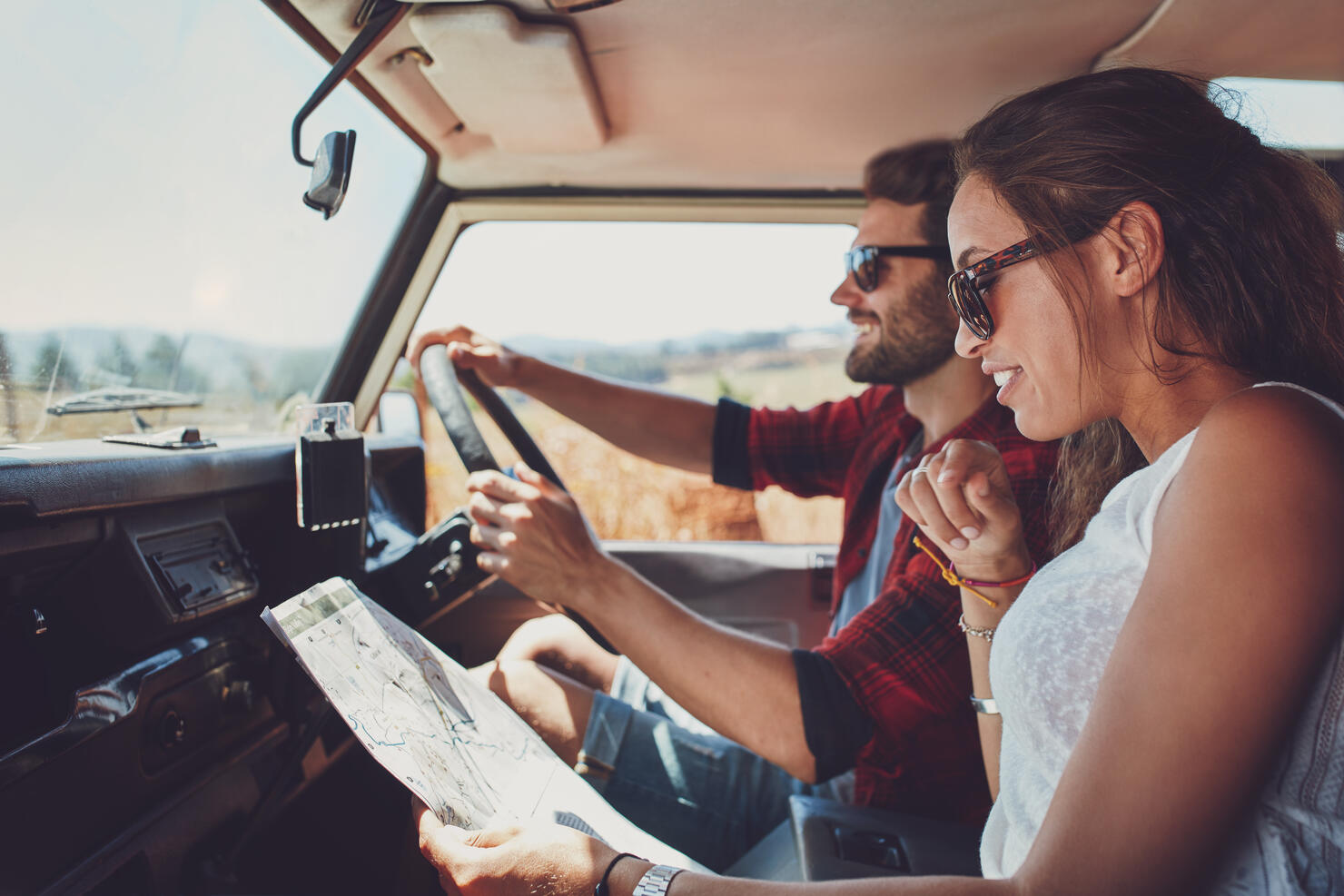 Young couple using a map on a roadtrip for directions