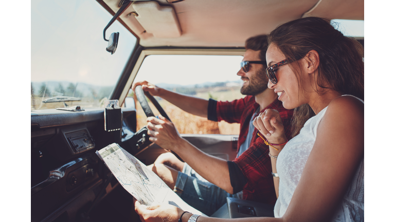 Young couple using a map on a roadtrip for directions