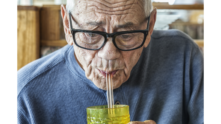 Elderly Senior Adult Man Drinking Water Through Two Straws