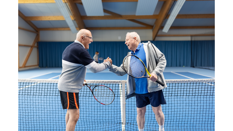 Senior tennis players greeting each other after a game of tennis