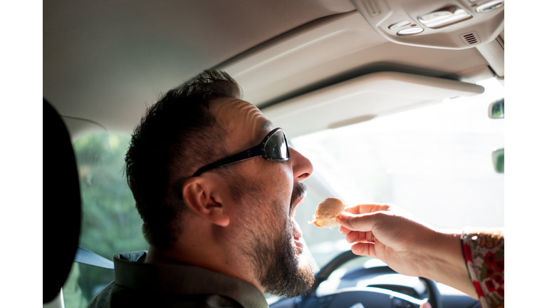 Man driving car and eating food