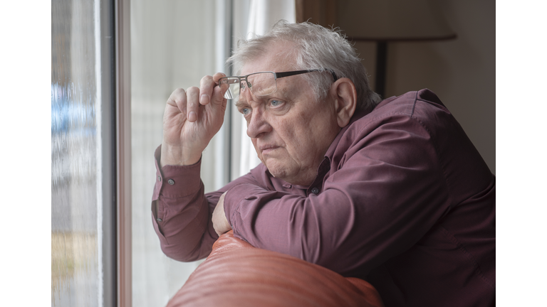 nosy neighbor looking at something out of his window