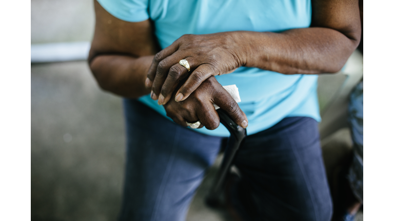 Close-up of senior black woman with hands folded over crane