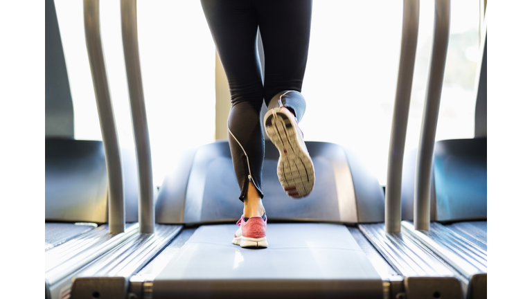 Low section of woman exercising on treadmill