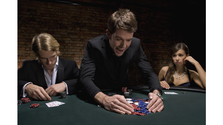 Man gathering poker chips in casino