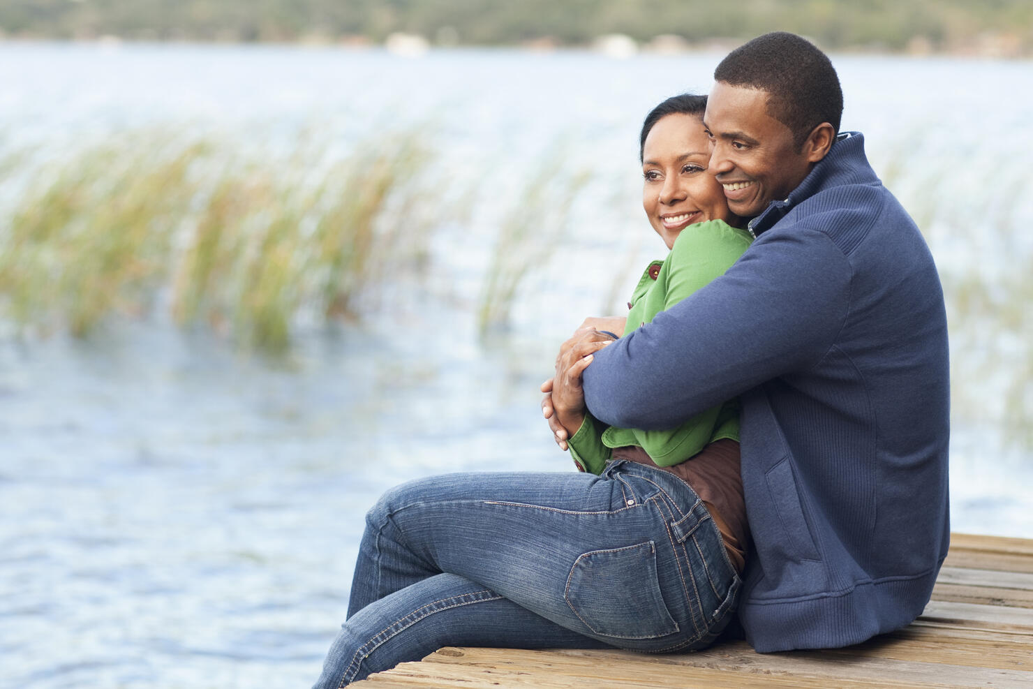 Smiling couple hugging on dock