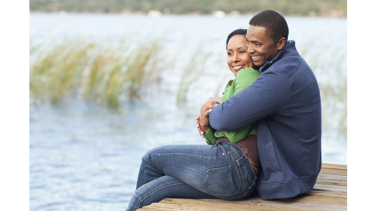 Smiling couple hugging on dock