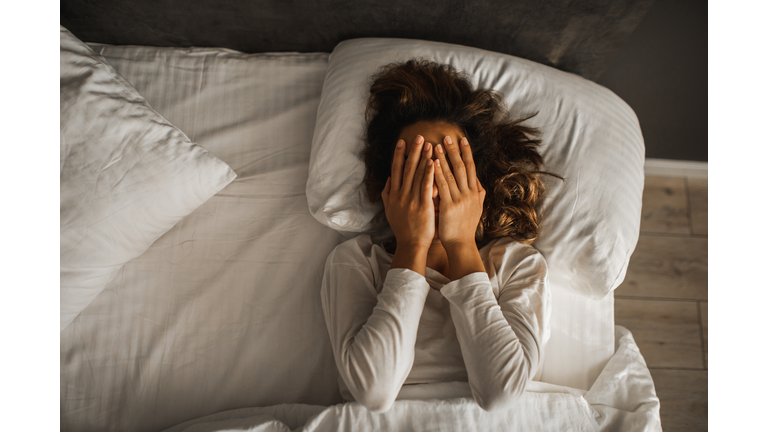 Woman in depression closed face with hands and crying in bed. Melancholy mood, mental health. Life problems