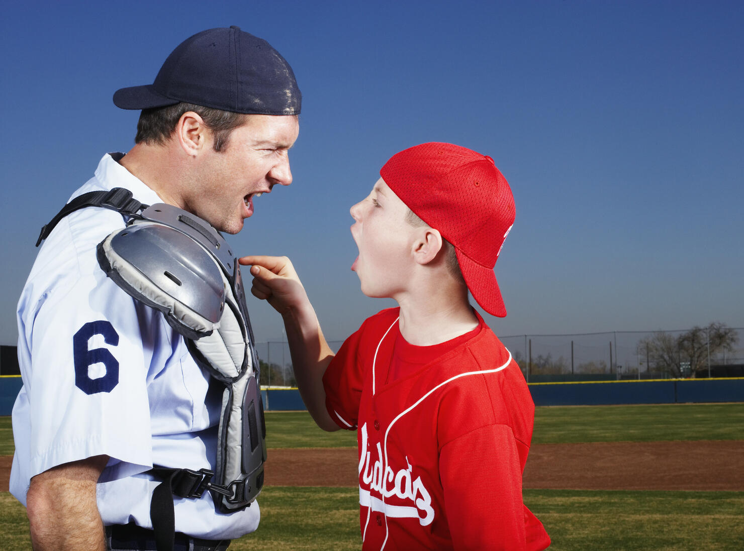 Young Baseball Player Arguing with Umpire