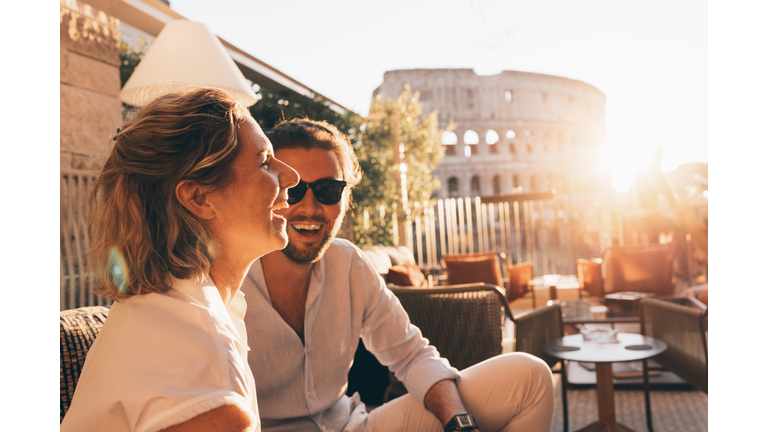 Romantic couple having fun at sunset in Rome, Italy. Colosseum and sunstar