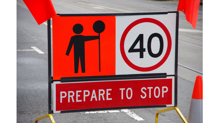 Signs warning drivers to prepare to stop, keep to a 40 kilomtre per hour speed limit and heed the worker with a stop sign