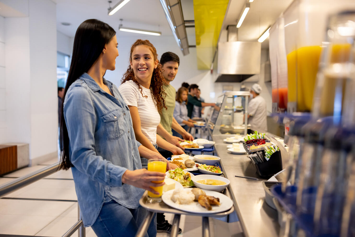 Happy women eating at a buffet style cafeteria