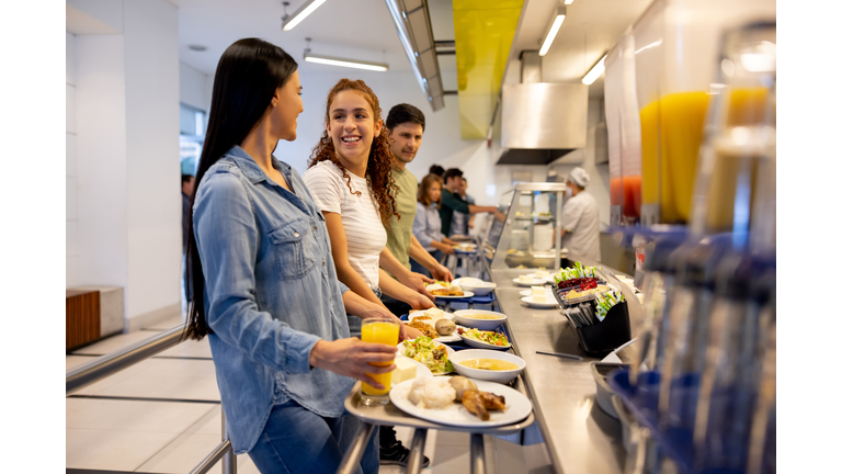 Happy women eating at a buffet style cafeteria
