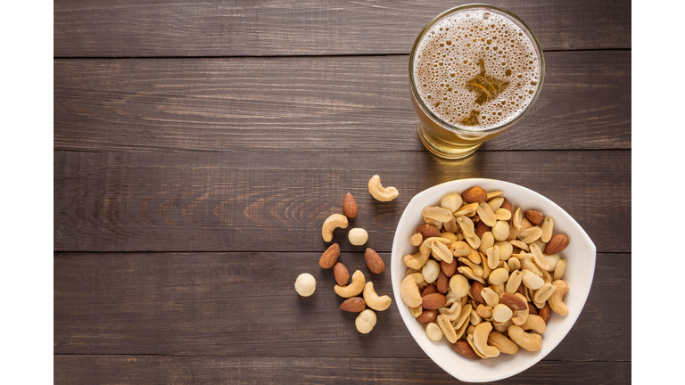 Glass of beer and almond, macadamia, peanut, cashew nut