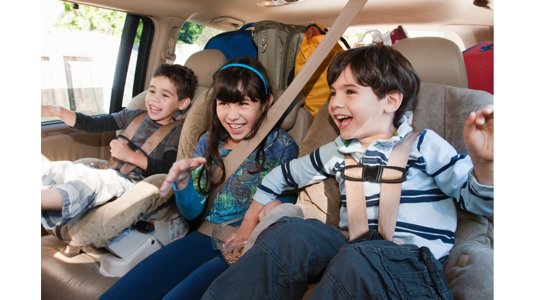 Three siblings in back seat of car