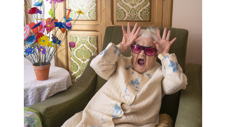 Funny elderly 90s woman gesture hands in head