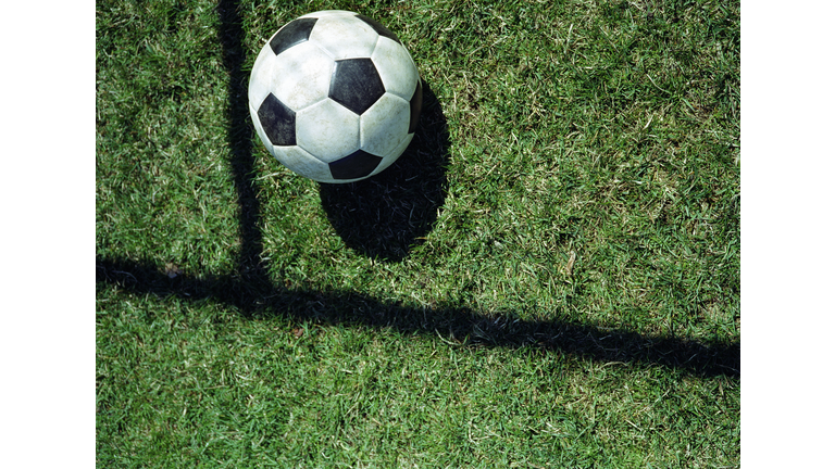 Soccer ball in shadow of goal, elevated view