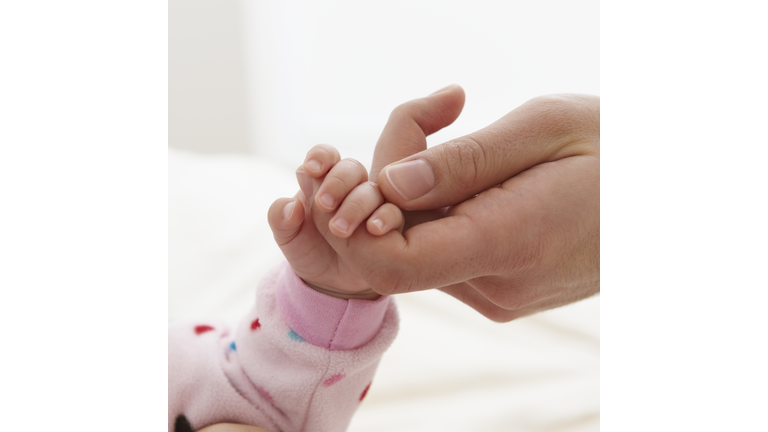 Baby Girl Holding Father's Finger