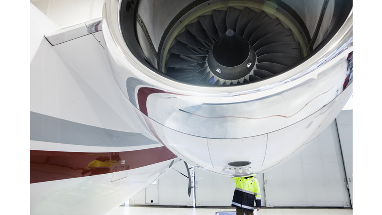 Aviation mechanic making repairs to jet plane