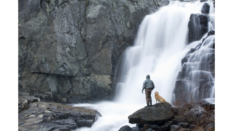 Fly fisherman on river in winter.