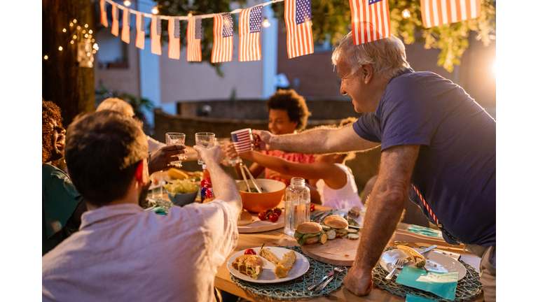 Multi-generation family having dinner outdoors on an American national holiday