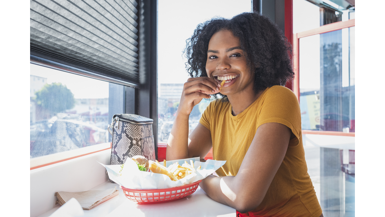 Young woman eating in diner